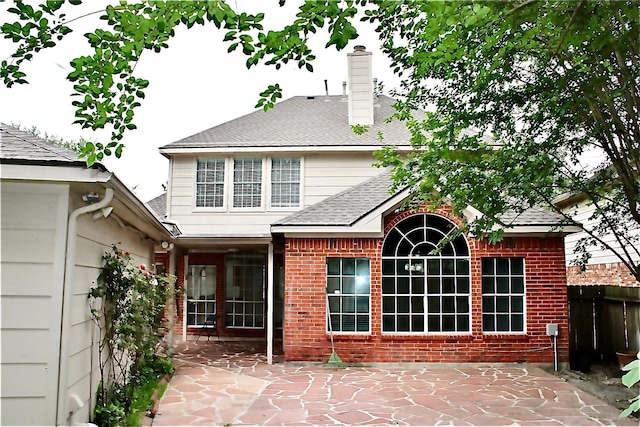 9619 Therrell Dr, Houston, TX 77064 - back of house with a patio area, a chimney, a shingled roof, and brick siding