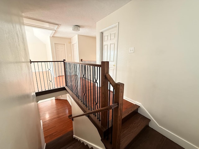 9619 Therrell Dr, Houston, TX 77064 - staircase featuring attic access, wood finished floors, baseboards, and a textured ceiling