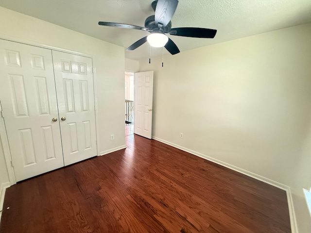 9619 Therrell Dr, Houston, TX 77064 - unfurnished bedroom featuring baseboards, dark wood-type flooring, a closet, and a ceiling fan