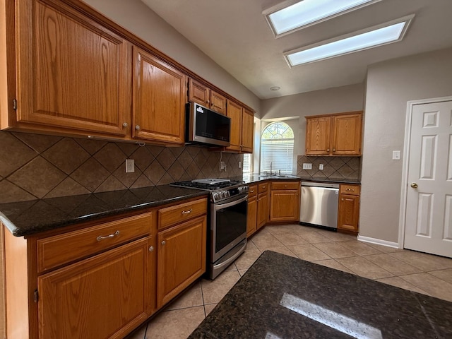 9619 Therrell Dr, Houston, TX 77064 - kitchen featuring appliances with stainless steel finishes, light tile patterned floors, brown cabinets, backsplash, and a sink