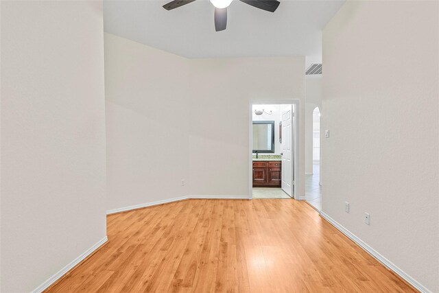 4907 Sundance Hollow Ln, Katy, TX 77494 - empty room with light wood finished floors, ceiling fan, and arched walkways