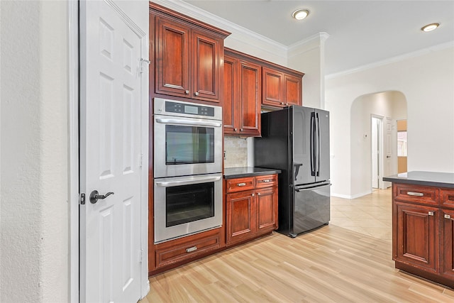 4907 Sundance Hollow Ln, Katy, TX 77494 - kitchen with stainless steel double oven, freestanding refrigerator, dark countertops, crown molding, and backsplash