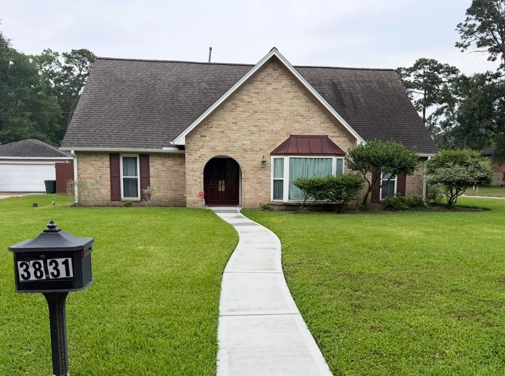 3831 Blue Spring Dr, Houston, TX 77068 - view of front facade featuring roof with shingles, brick siding, and a front lawn