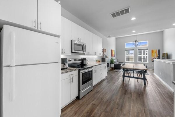 4908 Paradigm Ln, Spring, TX 77379 - kitchen with stainless steel appliances, white cabinets, dark wood finished floors, recessed lighting, and pendant lighting