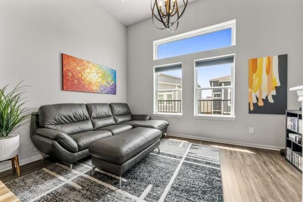 4908 Paradigm Ln, Spring, TX 77379 - living room with a chandelier, wood finished floors, a towering ceiling, and baseboards