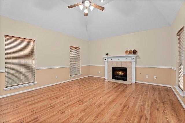 19918 Cypresswood Lake Dr, Spring, TX 77373 - unfurnished living room featuring vaulted ceiling, ceiling fan, light wood-style floors, a tile fireplace, and baseboards