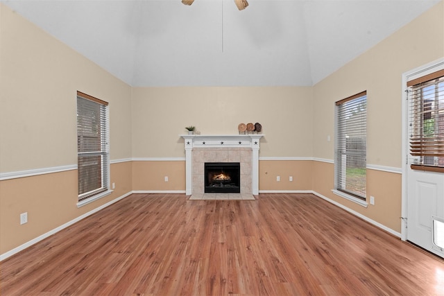 19918 Cypresswood Lake Dr, Spring, TX 77373 - unfurnished living room featuring light wood finished floors, a fireplace, vaulted ceiling, a ceiling fan, and baseboards