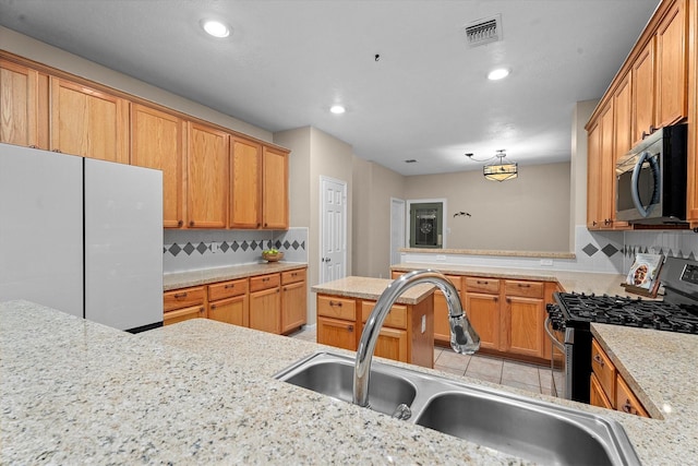 19918 Cypresswood Lake Dr, Spring, TX 77373 - kitchen featuring appliances with stainless steel finishes, a sink, recessed lighting, a peninsula, and tasteful backsplash
