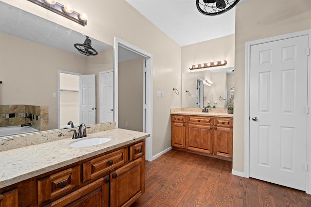 19918 Cypresswood Lake Dr, Spring, TX 77373 - bathroom featuring two vanities, wood finished floors, a bath, and baseboards