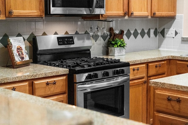 19918 Cypresswood Lake Dr, Spring, TX 77373 - kitchen featuring stainless steel appliances, light countertops, backsplash, and brown cabinetry