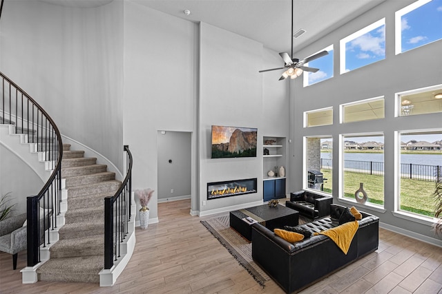 3002 Secret Lagoon Ln, Texas City, TX 77568 - living room featuring healthy amount of natural light, a high ceiling, wood finished floors, and stairway
