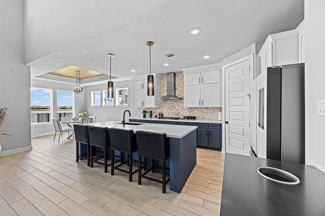 3002 Secret Lagoon Ln, Texas City, TX 77568 - kitchen with wall chimney range hood, a sink, appliances with stainless steel finishes, a kitchen breakfast bar, and white cabinets
