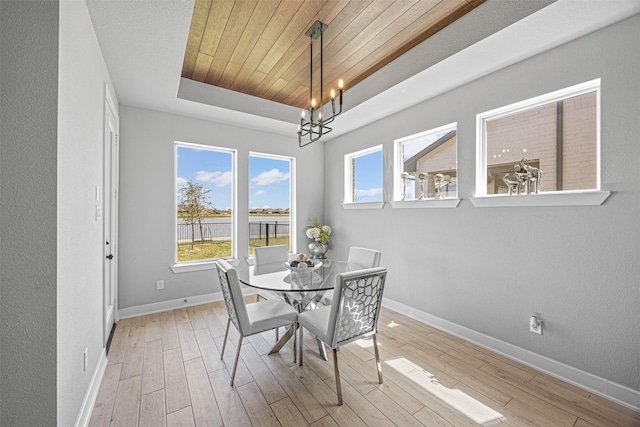 3002 Secret Lagoon Ln, Texas City, TX 77568 - dining space featuring a tray ceiling, a chandelier, baseboards, light wood-style floors, and wooden ceiling