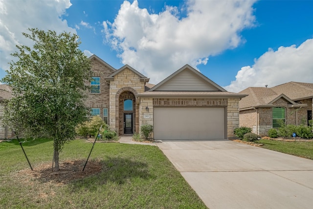 23922 Olivenza Trl, New Caney, TX 77357 - view of front facade with an attached garage, driveway, a front yard, and stone siding