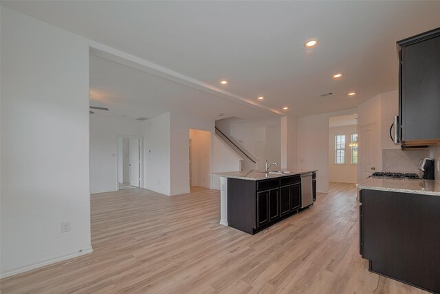 23922 Olivenza Trl, New Caney, TX 77357 - kitchen with appliances with stainless steel finishes, open floor plan, light wood finished floors, a kitchen island with sink, and recessed lighting
