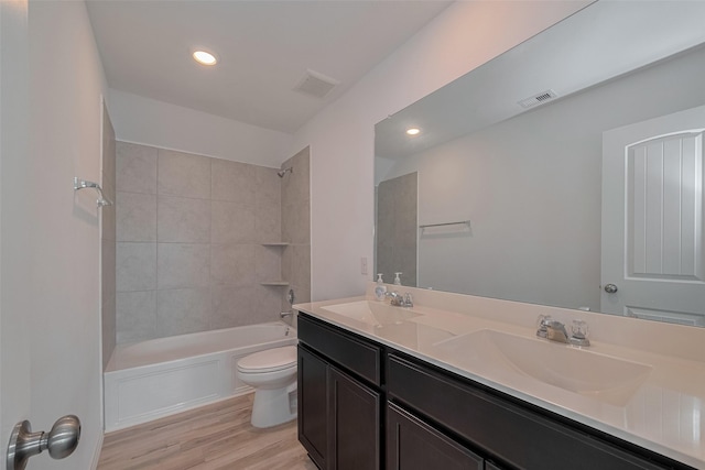 23922 Olivenza Trl, New Caney, TX 77357 - bathroom featuring double vanity, wood finished floors, bathing tub / shower combination, and recessed lighting