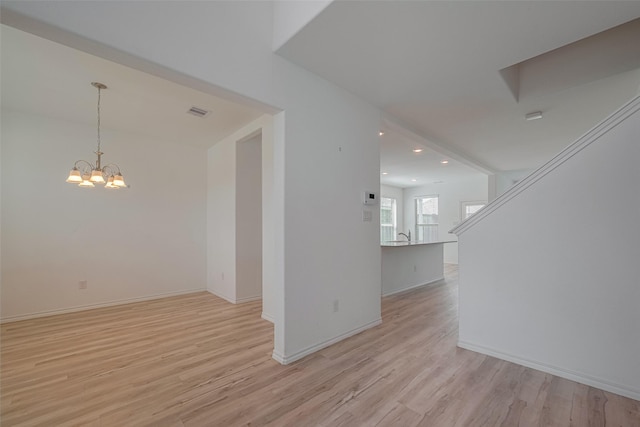 23922 Olivenza Trl, New Caney, TX 77357 - unfurnished living room with light wood-style floors, a chandelier, and recessed lighting