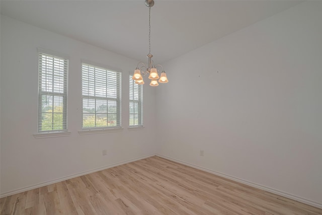 23922 Olivenza Trl, New Caney, TX 77357 - spare room with light wood-style flooring and a chandelier