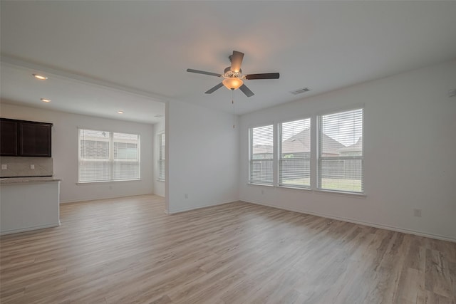 23922 Olivenza Trl, New Caney, TX 77357 - unfurnished living room with plenty of natural light, light wood-style flooring, ceiling fan, and recessed lighting