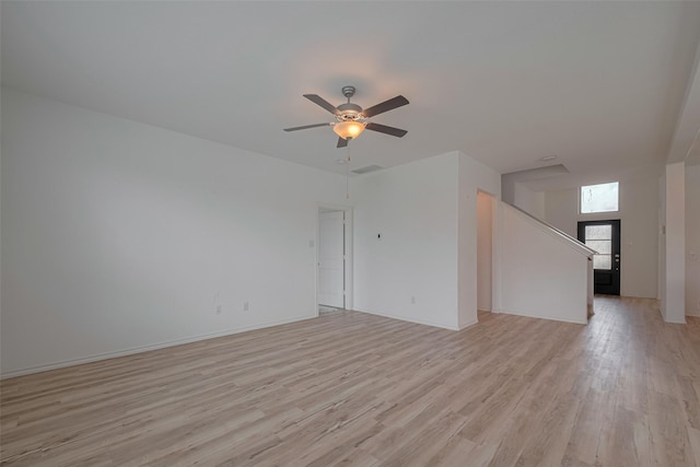 23922 Olivenza Trl, New Caney, TX 77357 - unfurnished living room with light wood-style flooring, ceiling fan, and stairs