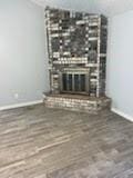 13323 S Thorntree Dr, Houston, TX 77015 - unfurnished living room with a brick fireplace, baseboards, and wood finished floors