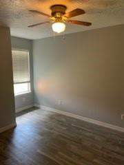 13323 S Thorntree Dr, Houston, TX 77015 - spare room with a ceiling fan, dark wood-style flooring, and baseboards