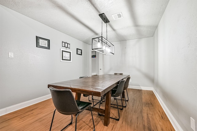 2307 Jackson Ln, League City, TX 77573 - dining space featuring baseboards, light wood-style floors, and a textured ceiling