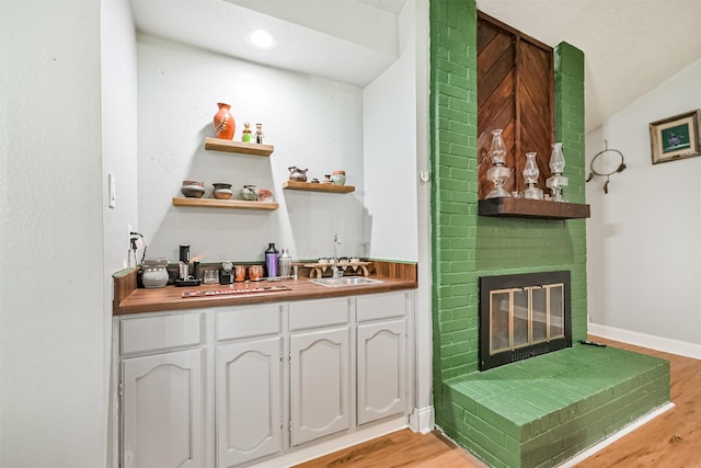 2307 Jackson Ln, League City, TX 77573 - indoor wet bar with light wood-type flooring, a fireplace, and vaulted ceiling