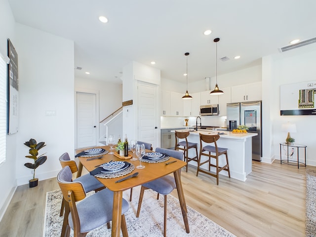 3004 Jensen Springs Ln, Houston, TX 77026 - dining area with light wood finished floors, recessed lighting, and stairway