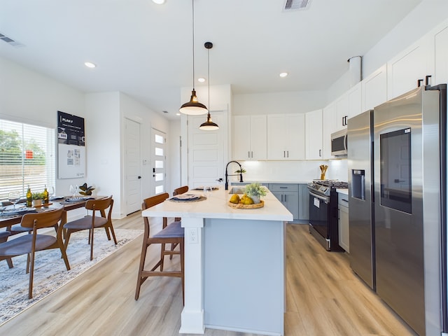 3004 Jensen Springs Ln, Houston, TX 77026 - kitchen featuring appliances with stainless steel finishes, light wood-style flooring, plenty of natural light, light countertops, and recessed lighting