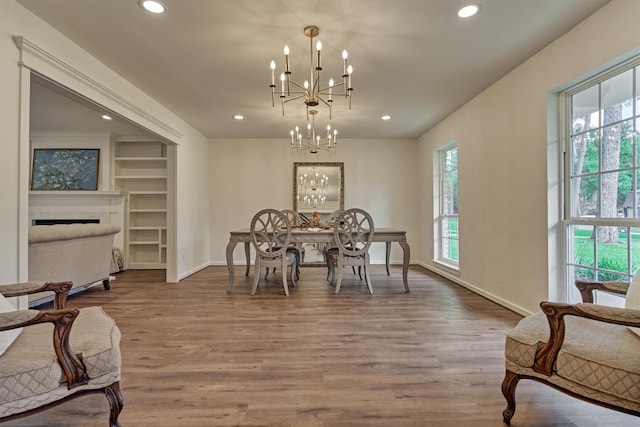 6326 Bayonne Dr, Spring, TX 77389 - dining area with a chandelier, wood finished floors, recessed lighting, baseboards, and a fireplace