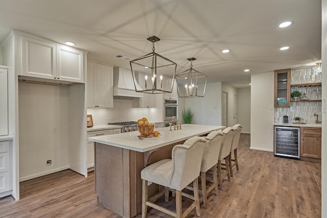 6326 Bayonne Dr, Spring, TX 77389 - kitchen featuring beverage cooler, custom exhaust hood, recessed lighting, backsplash, and wood finished floors