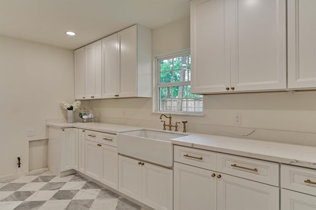 6326 Bayonne Dr, Spring, TX 77389 - kitchen featuring a sink, white cabinets, light stone countertops, recessed lighting, and baseboards