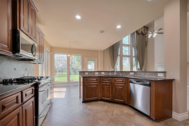 4131 Regal Stone Ln, Sugar Land, TX 77479 - kitchen featuring appliances with stainless steel finishes, a sink, decorative backsplash, plenty of natural light, and recessed lighting