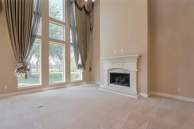 4131 Regal Stone Ln, Sugar Land, TX 77479 - unfurnished living room with carpet flooring, a fireplace with raised hearth, baseboards, and a high ceiling