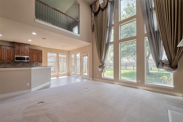 4131 Regal Stone Ln, Sugar Land, TX 77479 - unfurnished living room with light carpet, baseboards, a towering ceiling, and recessed lighting