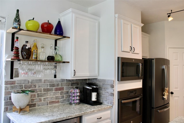 3231 Brinton Trails Ln, Katy, TX 77494 - kitchen featuring appliances with stainless steel finishes, open shelves, white cabinetry, and decorative backsplash