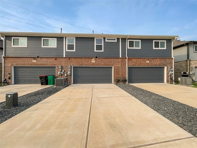 8022 Scanlan Trce, Missouri City, TX 77459 - townhome / multi-family property featuring an attached garage, cooling unit, concrete driveway, and brick siding