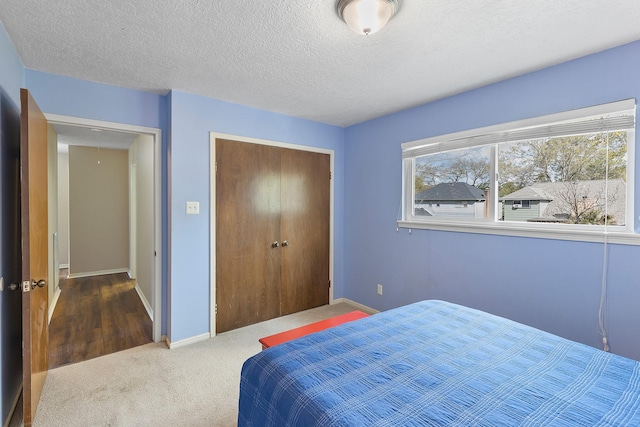 7514 Renmark Ln, Houston, TX 77070 - carpeted bedroom featuring a closet, a textured ceiling, and baseboards