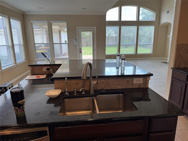 11703 Sterling Brook St, Pearland, TX 77584 - kitchen featuring an island with sink, a sink, healthy amount of natural light, dark stone countertops, and crown molding