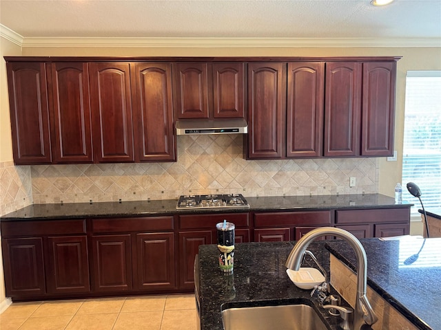 11703 Sterling Brook St, Pearland, TX 77584 - kitchen with stainless steel gas stovetop, a sink, ornamental molding, under cabinet range hood, and dark stone counters