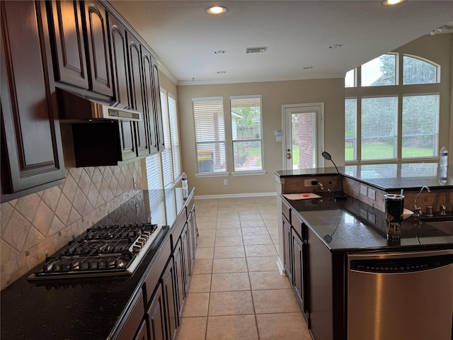 11703 Sterling Brook St, Pearland, TX 77584 - kitchen with stainless steel appliances, dark stone countertops, healthy amount of natural light, ornamental molding, and recessed lighting