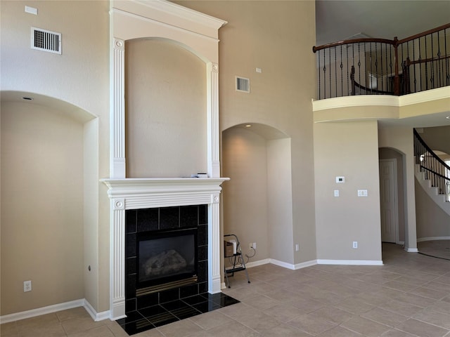 11703 Sterling Brook St, Pearland, TX 77584 - unfurnished living room with a fireplace, tile patterned floors, stairs, baseboards, and a towering ceiling