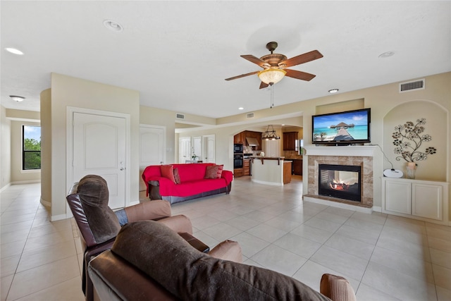 303 Winkler St, Baytown, TX 77520 - living area featuring light tile patterned floors, arched walkways, a ceiling fan, a tile fireplace, and recessed lighting
