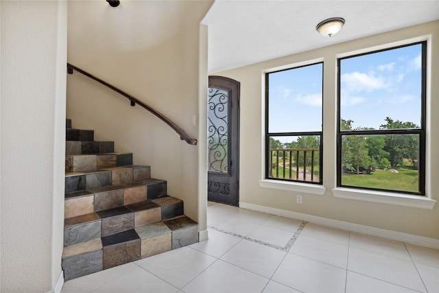 303 Winkler St, Baytown, TX 77520 - stairs with baseboards, tile patterned flooring, and arched walkways