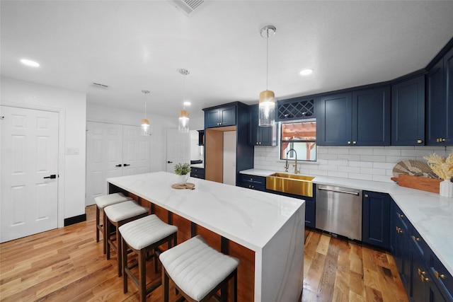 701 W 39th St, Houston, TX 77018 - kitchen featuring stainless steel dishwasher, a sink, blue cabinets, light wood-style flooring, and recessed lighting