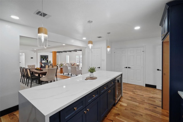 701 W 39th St, Houston, TX 77018 - kitchen featuring wine cooler, light wood finished floors, recessed lighting, hanging light fixtures, and a kitchen island