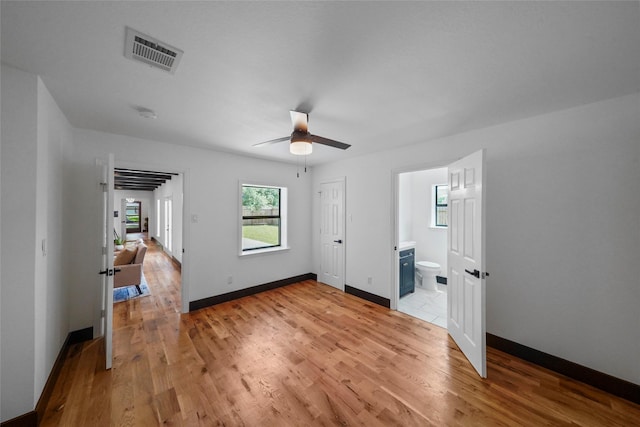 701 W 39th St, Houston, TX 77018 - unfurnished bedroom featuring light wood-style flooring, baseboards, ensuite bath, and a ceiling fan