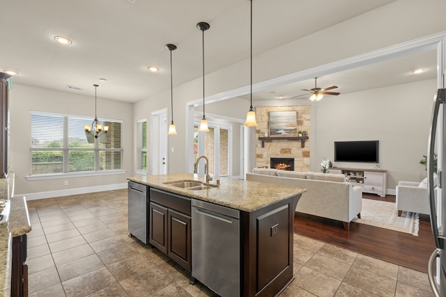 4215 Orchard Arbor Ln, Sugar Land, TX 77479 - kitchen featuring a sink, a stone fireplace, dishwasher, dark brown cabinets, and baseboards