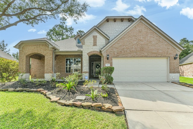 16802 Cherokee Lake Ln, Houston, TX 77044 - view of front of home featuring brick siding, a garage, concrete driveway, stone siding, and a front yard
